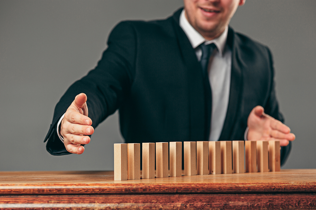 Man and wooden cubes on table. Management concept